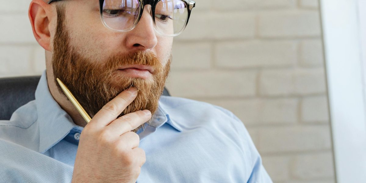 A manager contemplating a decision, representing the challenge of balancing efficiency with human well-being.