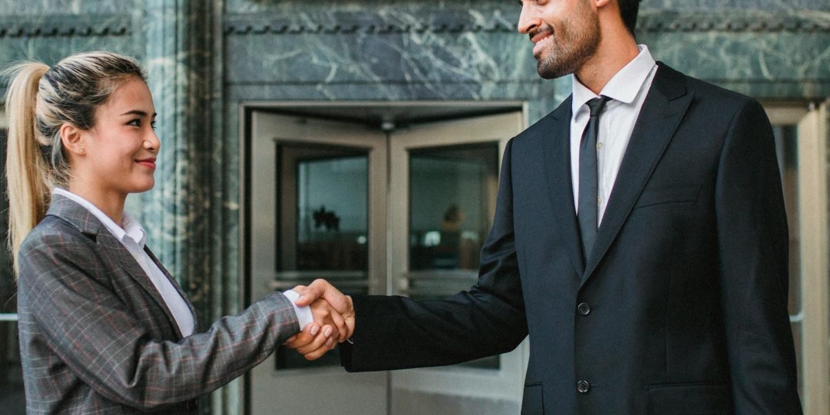 Two professionals sealing a deal or celebrating a new opportunity with a firm handshake.